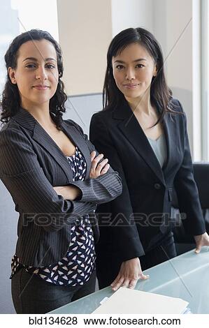 Stock Photo - Businesswomen smiling together in office. Fotosearch
