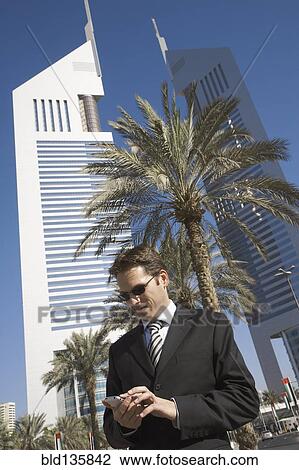 Caucasian businessman using cell phone, Dubai, United Arab Emirates View Large Photo Image Stock Image - Caucasian businessman using cell phone, Dubai, United Arab Emirates. Fotosearch