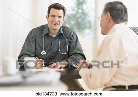 Stock Image - Caucasian doctor and patient talking in office. Fotosearch