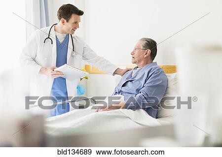 Caucasian doctor talking to Senior patient in hospital View Large Photo Image Stock Photo - Caucasian doctor talking to Senior patient in hospital. Fotosearch