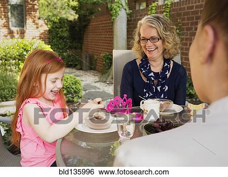 Caucasian family eating together in backyard View Large Photo Image Stock Photograph - Caucasian family eating together in backyard. Fotosearch