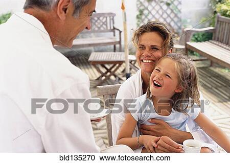 Caucasian family relaxing on patio View Large Photo Image Stock Image - Caucasian family relaxing on patio. Fotosearch