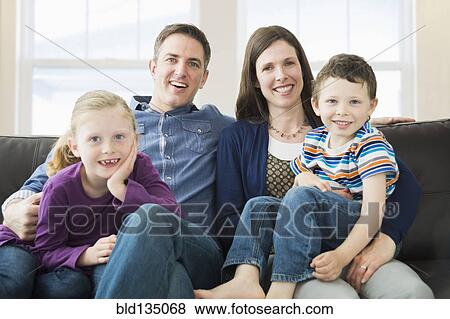 Caucasian family relaxing on sofa View Large Photo Image Stock Photo - Caucasian family relaxing on sofa. Fotosearch