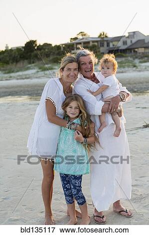 Caucasian family smiling on beach View Large Photo Image Stock Photo - Caucasian family smiling on beach. Fotosearch