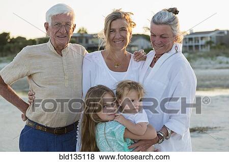 Stock Photo - Caucasian family smiling on beach. Fotosearch