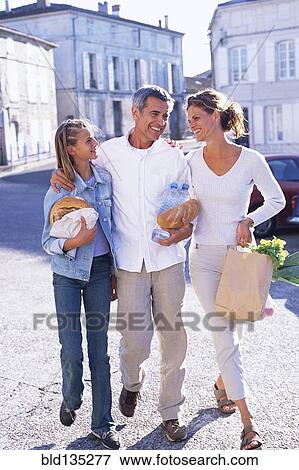 Caucasian family walking on village street View Large Photo Image Stock Photo - Caucasian family walking on village street. Fotosearch
