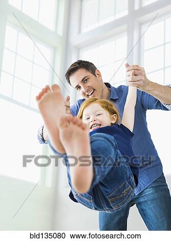 Stock Image - Caucasian father and daughter playing. Fotosearch