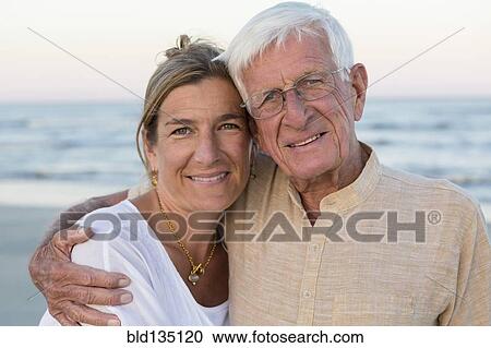 Stock Image - Caucasian father and daughter smiling on beach. Fotosearch