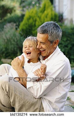 Picture - Caucasian father and son hugging outdoors. Fotosearch