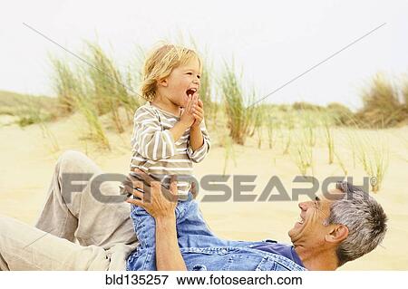 Caucasian father and son playing on beach View Large Photo Image Stock Photo - Caucasian father and son playing on beach. Fotosearch