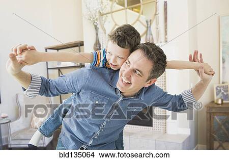 Picture - Caucasian father and son playing together. Fotosearch