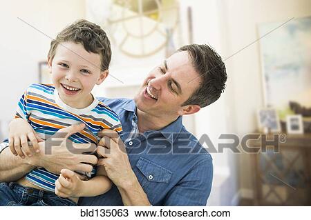 Stock Image - Caucasian father and son playing together. Fotosearch