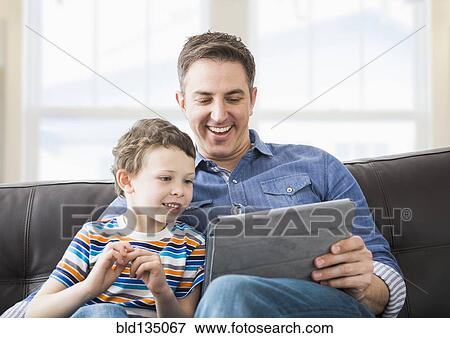 Stock Photo - Caucasian father and son using tablet computer. Fotosearch