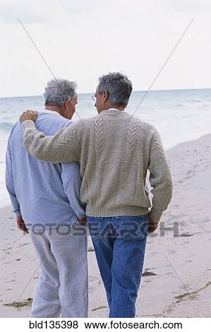 Caucasian father and son walking on beach View Large Photo Image Stock Photo - Caucasian father and son walking on beach. Fotosearch