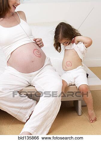 Caucasian girl and pregnant mother with drawings on bellies View Large Photo Image Stock Photograph - Caucasian girl and pregnant mother with drawings on bellies. Fotosearch
