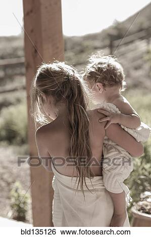 Caucasian girl carrying baby brother on porch View Large Photo Image Stock Photograph - Caucasian girl carrying baby brother on porch. Fotosearch