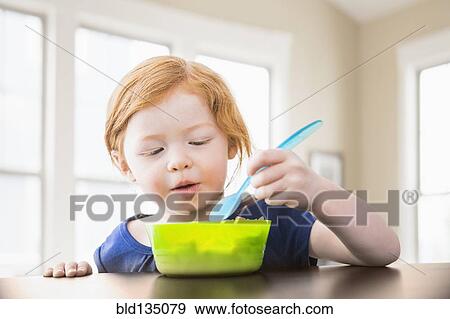 Caucasian girl eating at table View Large Photo Image Stock Photo - Caucasian girl eating at table. Fotosearch