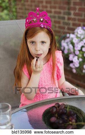 Caucasian girl eating fruit in backyard View Large Photo Image Stock Photo - Caucasian girl eating fruit in backyard. Fotosearch