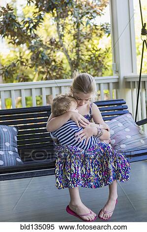 Caucasian girl holding brother on porch swing View Large Photo Image Stock Photography - Caucasian girl holding brother on porch swing. Fotosearch