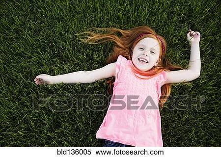 Stock Photography - Caucasian girl laying in grass. Fotosearch