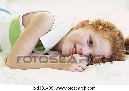 Caucasian girl laying on bed View Large Photo Image Stock Image - Caucasian girl laying on bed. Fotosearch