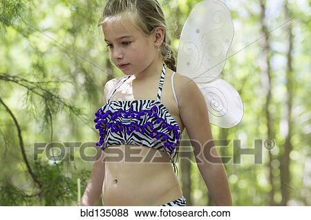 Stock Photo - Caucasian girl playing dress up in forest. Fotosearch