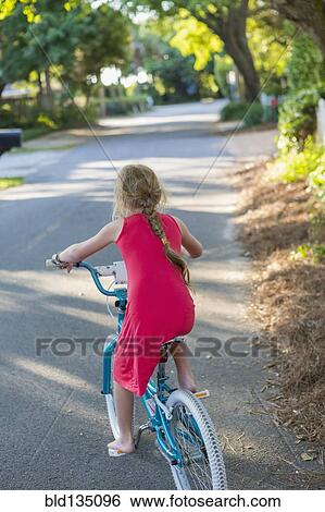 Caucasian girl riding bicycle on street View Large Photo Image Stock Photograph - Caucasian girl riding bicycle on street. Fotosearch