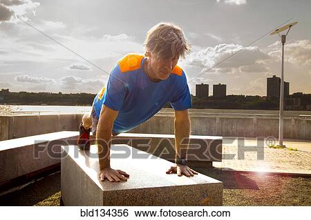 Caucasian man doing push ups in urban park View Large Photo Image Stock Photograph - Caucasian man doing push ups in urban park. Fotosearch