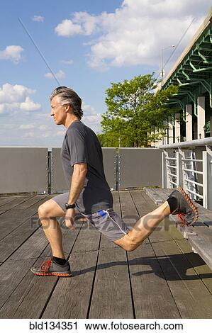 Caucasian man exercising on urban deck View Large Photo Image Stock Image - Caucasian man exercising on urban deck. Fotosearch