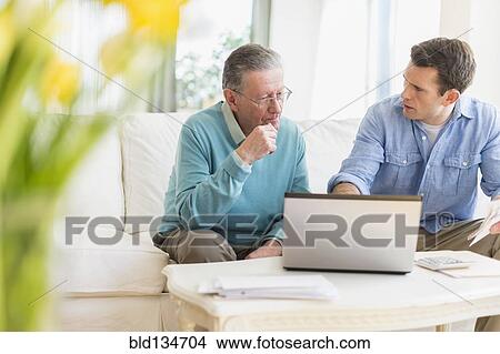 Caucasian man helping father use computer View Large Photo Image Picture - Caucasian man helping father use computer. Fotosearch
