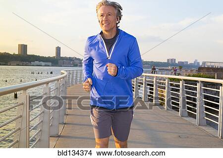 Caucasian man jogging on urban waterfront View Large Photo Image Picture - Caucasian man jogging on urban waterfront. Fotosearch