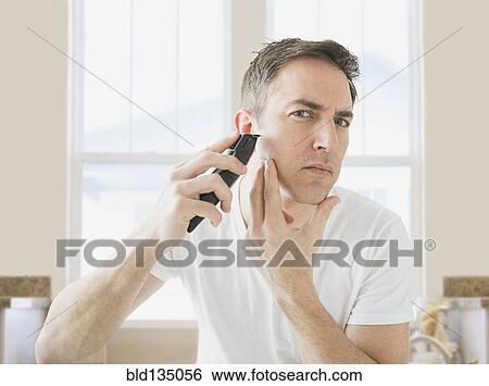 Caucasian man shaving in bathroom View Large Photo Image Stock Photograph - Caucasian man shaving in bathroom. Fotosearch