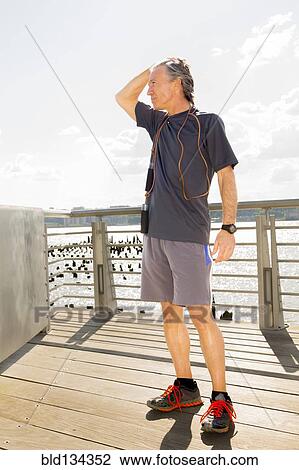 Caucasian man standing on wooden deck View Large Photo Image Stock Image - Caucasian man standing on wooden deck. Fotosearch