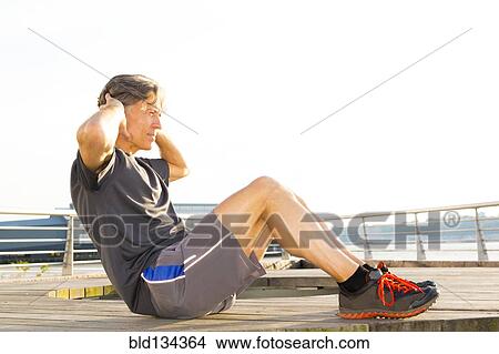 Caucasian man stretching in waterfront park View Large Photo Image Picture - Caucasian man stretching in waterfront park. Fotosearch