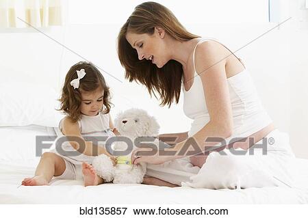 Caucasian mother and daughter playing with teddy bear View Large Photo Image Stock Photo - Caucasian mother and daughter playing with teddy bear. Fotosearch