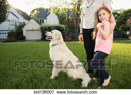 Stock Photo - Caucasian mother and daughter with dog in park. Fotosearch