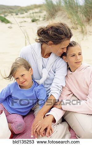 Caucasian mother and daughters hugging on beach View Large Photo Image Stock Image - Caucasian mother and daughters hugging on beach. Fotosearch