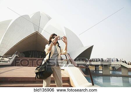 Stock Photograph - Caucasian tourist taking pictures at Bahai Temple, Delhi, India. Fotosearch