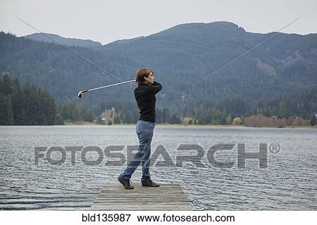 Caucasian woman golfing into lake View Large Photo Image Stock Photo - Caucasian woman golfing into lake. Fotosearch