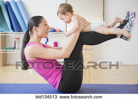 Caucasian woman holding baby on yoga mat View Large Photo Image Stock Image - Caucasian woman holding baby on yoga mat. Fotosearch
