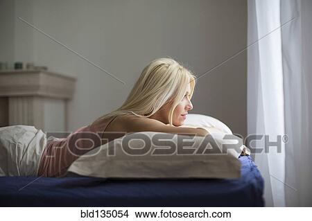 Picture - Caucasian woman laying in bed. Fotosearch