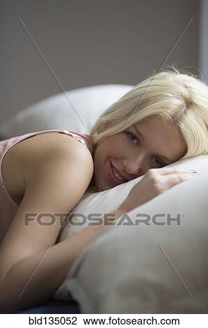 Stock Image - Caucasian woman laying in bed. Fotosearch