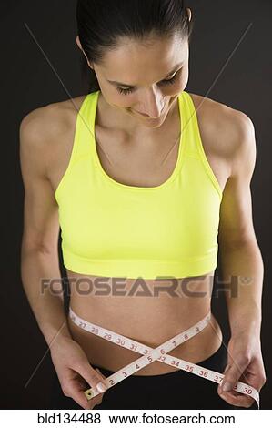 Caucasian woman measuring bare stomach View Large Photo Image Stock Photo - Caucasian woman measuring bare stomach. Fotosearch