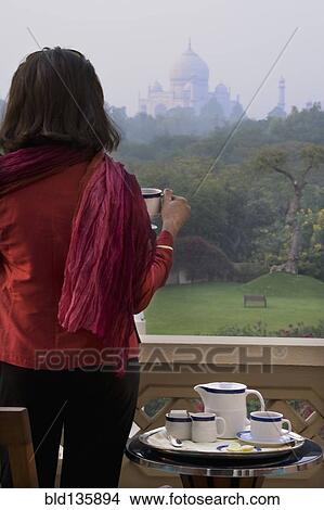 Caucasian woman overlooking Taj Mahal from balcony, Agra, India View Large Photo Image Picture - Caucasian woman overlooking Taj Mahal from balcony, Agra, India. Fotosearch