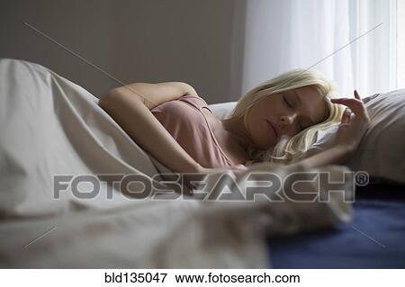 Caucasian woman sleeping in bed View Large Photo Image Stock Photo - Caucasian woman sleeping in bed. Fotosearch