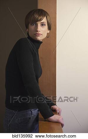Stock Image - Caucasian woman standing at banister. Fotosearch