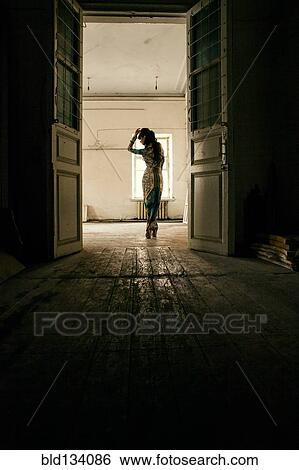 Stock Photograph - Caucasian woman standing in dilapidated house. Fotosearch