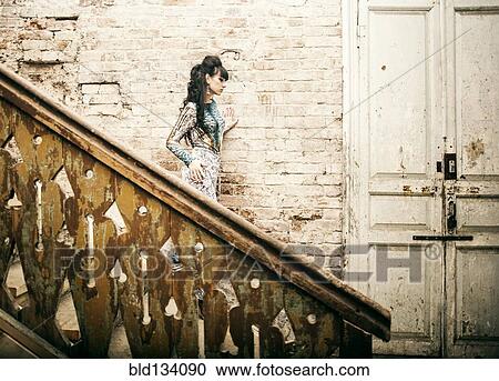 Caucasian woman standing on staircase in dilapidated house View Large Photo Image Stock Image - Caucasian woman standing on staircase in dilapidated house. Fotosearch