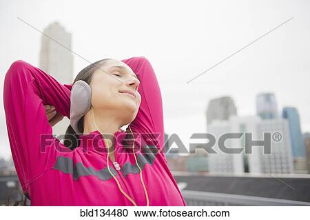 Stock Image - Caucasian woman stretching in city. Fotosearch