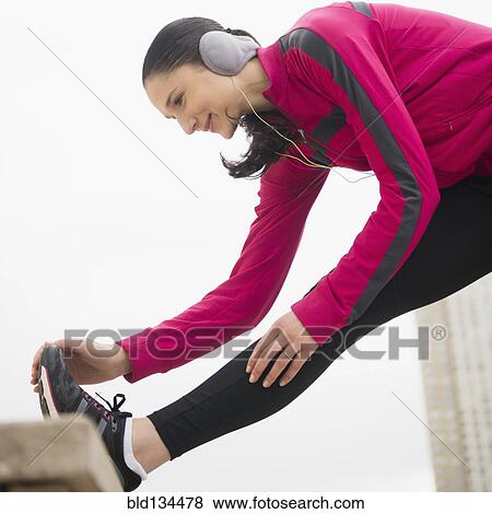 Stock Photo - Caucasian woman stretching leg. Fotosearch